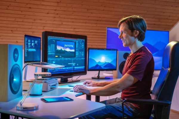 portrait mann vor computer bei filmproduktion mit Kunstlicht